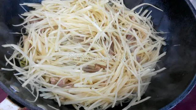 捞出切好的土豆丝放进锅，滴几滴醋炒匀。