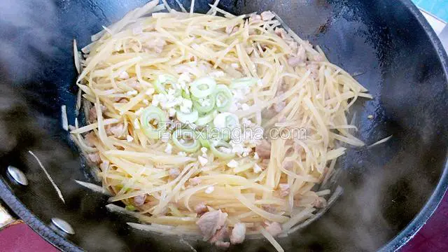 土豆丝熟后放入盐和鸡精调味，把剩下的葱花和蒜末放进去翻炒均匀。