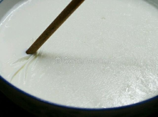用筷子将奶皮一边稍微挑开，把牛奶倒入另一个容器，奶皮留在碗中
