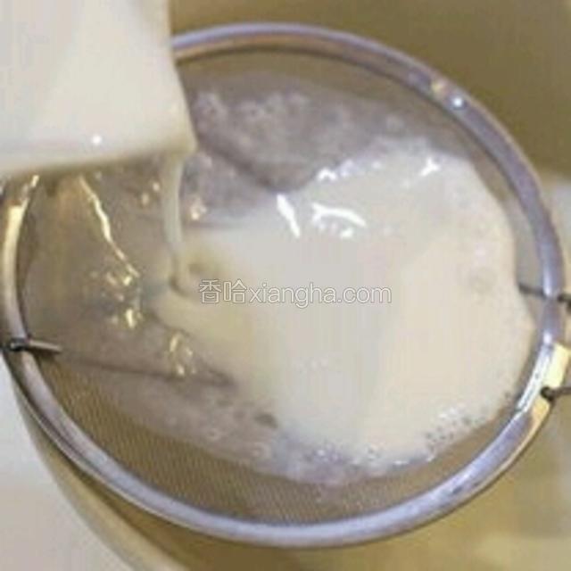 再把混合后的牛奶用筛网倒入留有奶皮的碗里，慢慢沿着边倒，奶皮就会浮起来