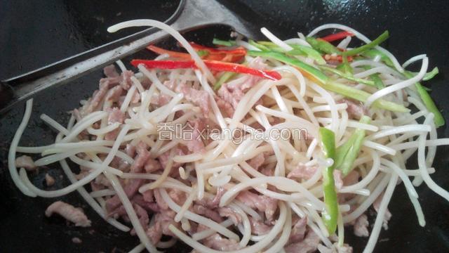 肉丝炒到八成熟时放入银芽菜，青红辣椒丝，炒1～2分钟。