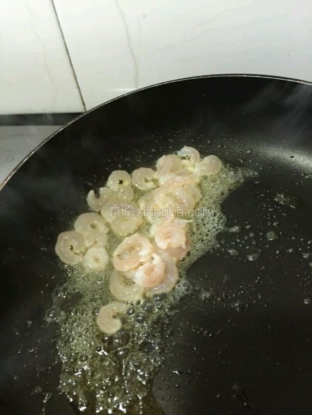 平底锅倒一点点油加热，倒入虾仁炒至变色捞起备用。 