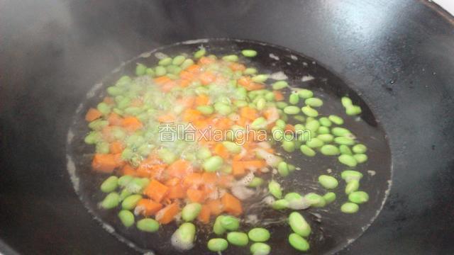 锅里置水烧沸到入胡萝卜，毛豆煮熟控干水盛出备用。