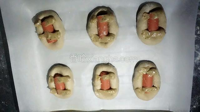 在放上火腿肠的面包上挤上黑胡椒沙拉酱