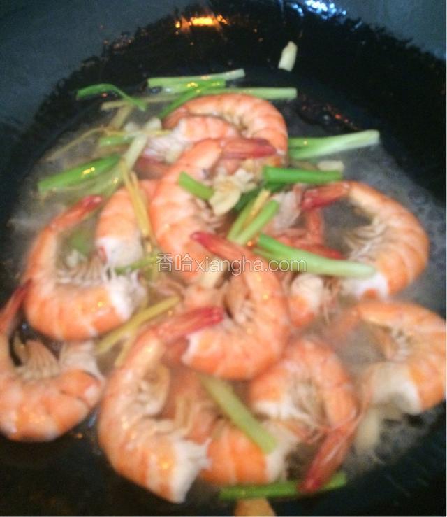 5成热时倒入大虾翻炒，马上倒入料酒，加入水，不要太多，没过虾一点应该就可以了，继续烧，火可以稍微关小一些。