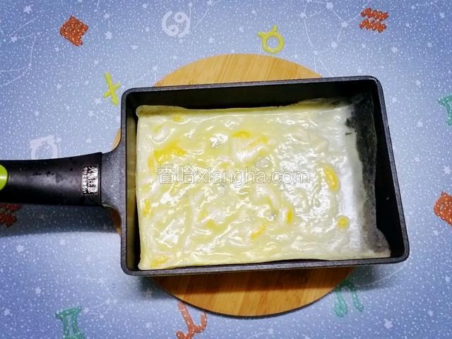 用紙巾醮油抹勻小鍋，開小火熱鍋，勺入一勺混合好的蛋液