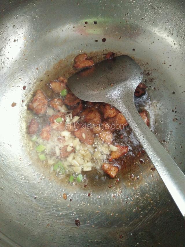 等五花肉炒到变色，倒入切好的葱蒜，爆香