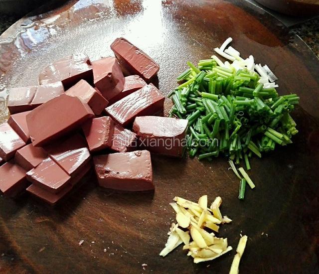 猪红洗一下切小块，姜洗好切丝，葱洗好切段
