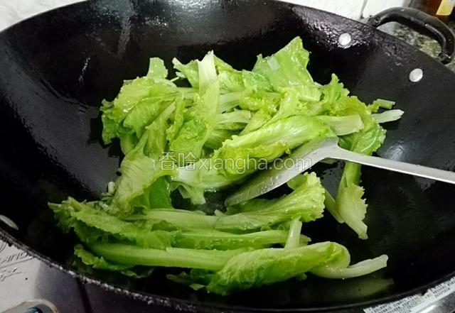 锅预热，入多一点花生油，油温热后放入葱白，生菜先少软