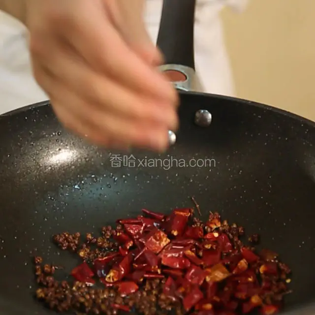 锅内再下约50克油，中火烧至5成热，放入葱姜蒜和干辣椒，花椒，爆出香味。