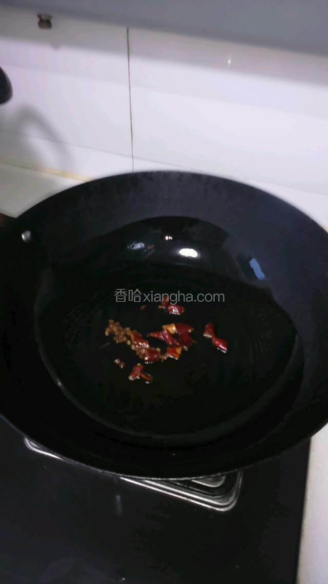 锅里放油烧制七成热，加辣椒胡椒粒，炒出香味。