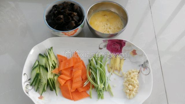 木耳摘好洗净，鸡蛋放少许料酒打散。黄瓜和胡萝卜切菱形块，葱和姜切丝，蒜切末。