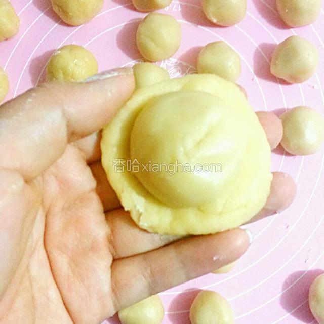 取一个水油皮压煸，放入一个油酥皮包好