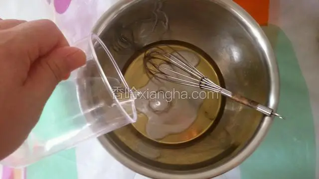 把食用油和水放入干净盆中，用手动蛋抽搅打融合