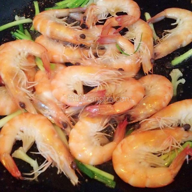 把沥干水分的虾倒入锅中烧炒锅上火，加入一点白糖提鲜。