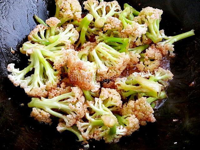 菜花变色后放入调好的汁翻炒，尝尝咸淡，如果淡就再加点盐，放入青椒翻炒均匀