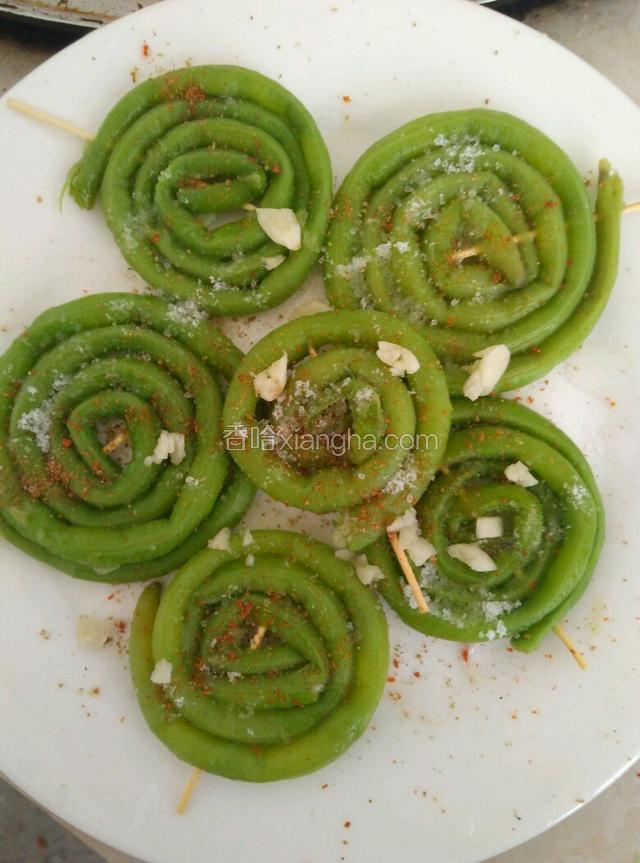 捞出过冷水，然后从头卷成卷，用竹签串起来。撒上孜然粉，芝麻，食盐，十三香，葱姜蒜沫。