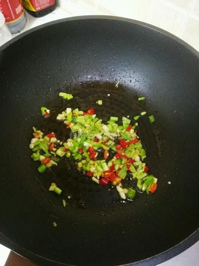 热锅倒油，油温五成热，放入姜，蒜，葱白，青椒末，红椒末煸炒出香味
