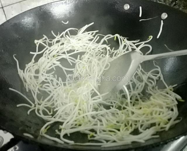 锅预热，放入花生油，油温热后先放入葱白，豆芽炒软