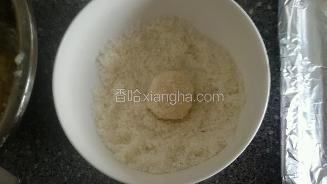 把小圆球放入留有10克的椰丝碗中滚匀，表皮粘满椰丝