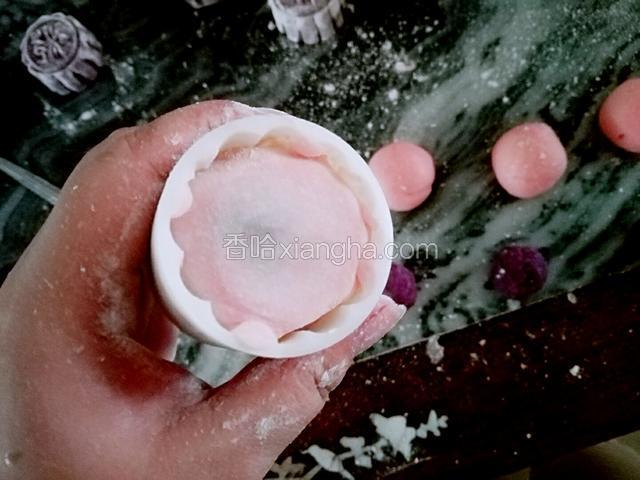 准备好一个50克的月饼模具，沾点糯米粉，把饼放上去按压，倒扣出来，