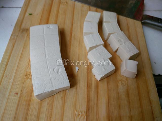 将买回来的豆腐，放入冰箱冰上一个钟，没有冰箱可放水泡上一个钟，这样做其实就是为了防止煮的时候容易碎，拿出来切小四方块，如图所示…
