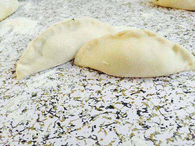 一手拿皮，一手放菜，对折捏边