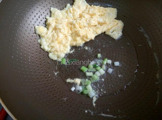 将炒好的鸡蛋拨到一旁，放入葱白爆香