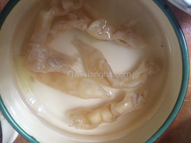 小白花胶加姜片煮沸捞起，换冷水泡发20分钟左右，剖片清洗花胶、洗净鱼油鱼血。