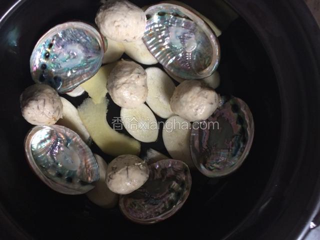 锅底依次铺上笋片、姜片，鲍鱼壳（鲍鱼干做的话可以省略），发菜丸子