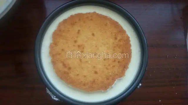 在到入剩余慕斯糊，取一片蛋糕抹上糖浆放入慕斯糊上面，用手轻轻按压蛋糕片，与慕斯平行入冰箱冷藏4个小时