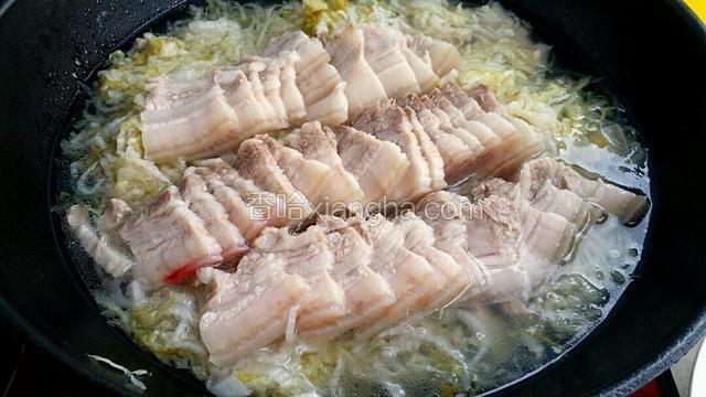 把炖好的肉捞出来切成片，把酸菜放入肉汤里，切好的肉片铺在酸菜上面。
