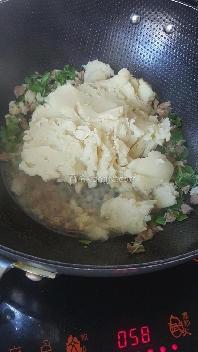 倒入土豆泥，快速翻炒，与肉丁，葱末充分搅匀