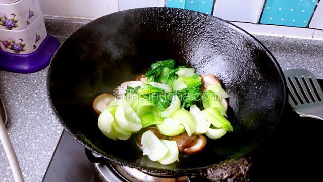 在放入油菜翻炒