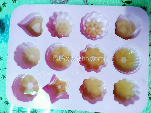 待温度稍降后，将玫瑰花溶液倒入一小层到布丁模具中。