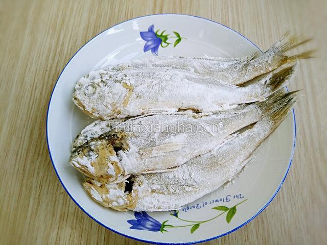 粘满面粉的鱼放在另一个盘子里备用，依次粘完所有的鱼。