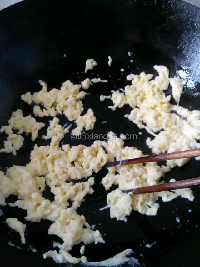迅速用筷子将鸡蛋在锅中打散，炒熟