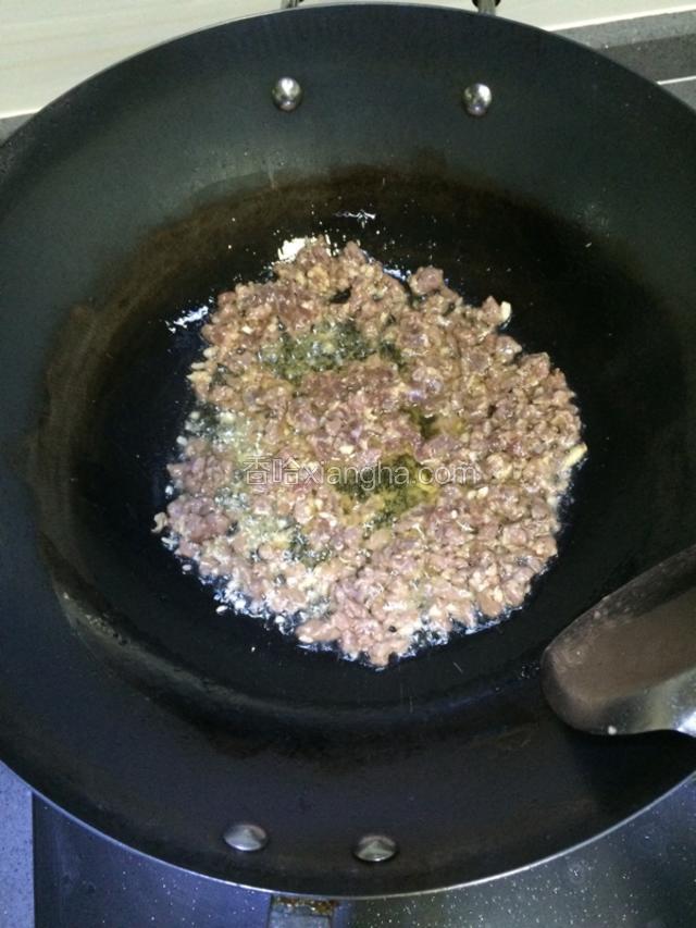 锅里烧热油，先把蒜末炒香，再加入腌制好的牛肉爆香