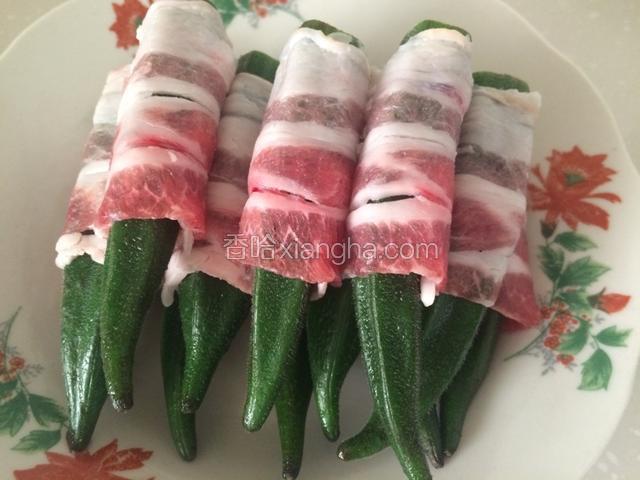 捞在清水里过凉后，切去蒂部，用五花肉片卷好；