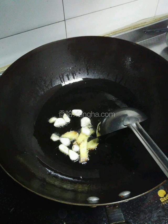 起锅热油至六成转小火倒入蒜片，姜片爆香