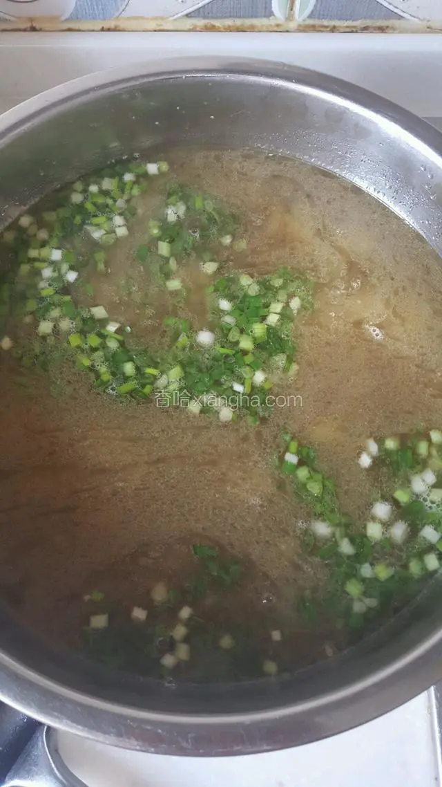 羊肉煮好的后，锅里还有很多汤，用小盆盛出，把香葱末倒入