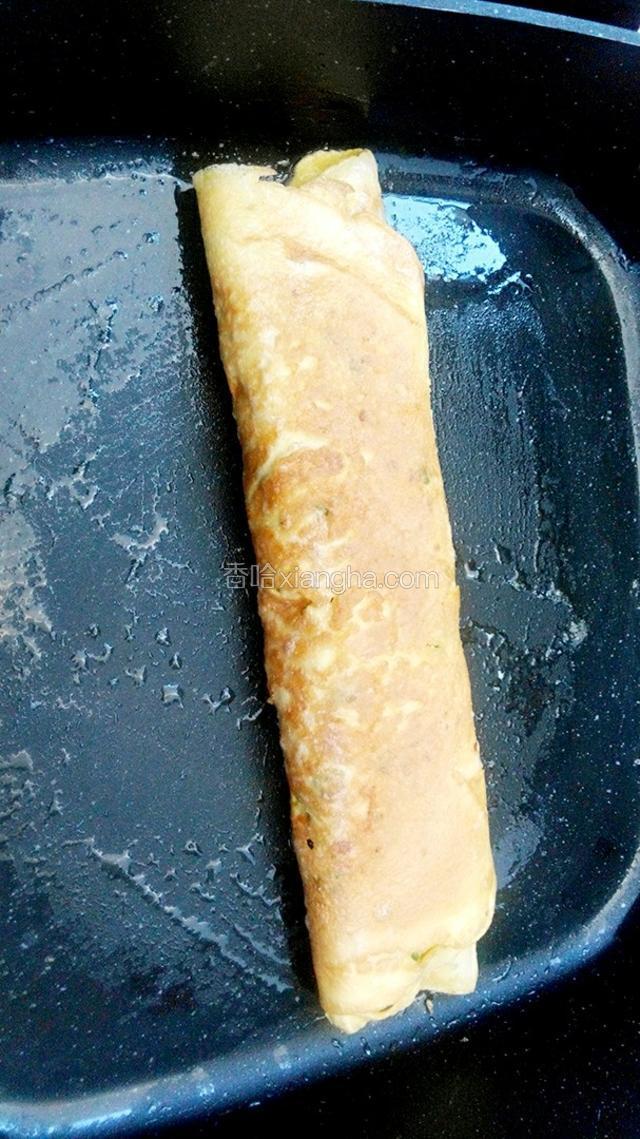 收好边后翻过来把封口压在下面煎一会，再翻过去煎另一面。