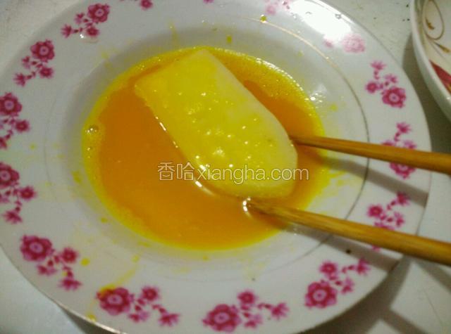 将切好的糍粑一块块裹上蛋液，两面都裹上。