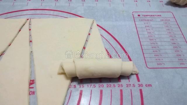 从宽的一头开始卷，尖部刷一点鸡蛋液。