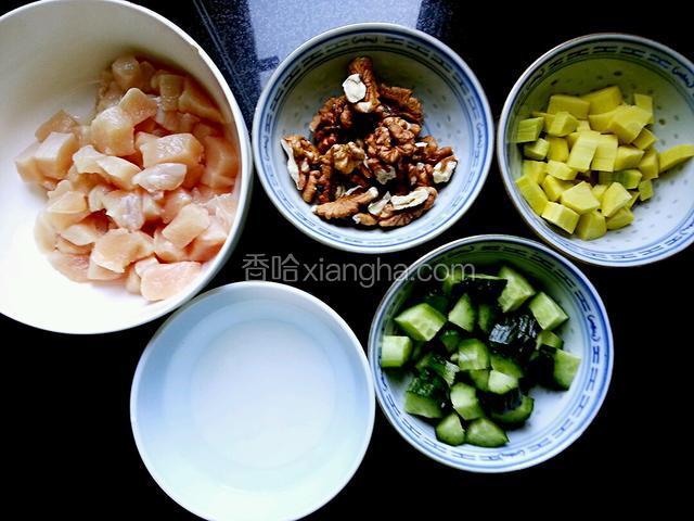 鸡胸切丁用少量盐、料酒腌制；黄瓜和胡萝卜切丁。看到那碗白色的了吧？那是沉淀着的水淀粉，把上面的水倒掉，只用湿淀粉把肉丁拌匀。