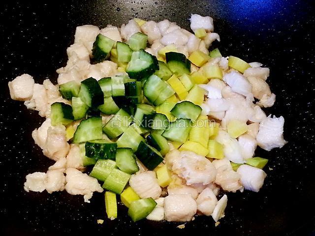 鸡丁变色后加入葱姜蒜和黄瓜、胡萝卜翻炒，加白糖、生抽，炒匀后加盐调味，可适当加一点热水