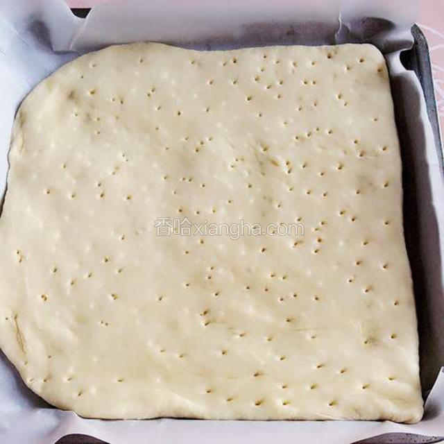 用擀面杖将面团擀成与烤盘几乎相同大小的薄饼，放入铺了油纸的烤盘内，面胚用牙签或者叉子扎一些小眼，放入烤箱进行第三次发酵四十分钟左右；