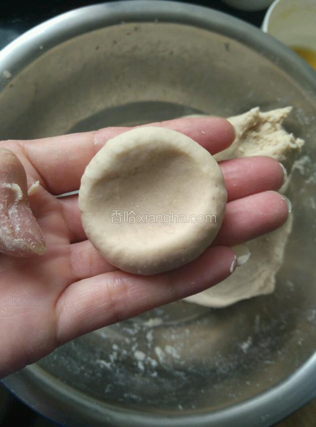 取一小块皮揉圆，用拇指捏扁。