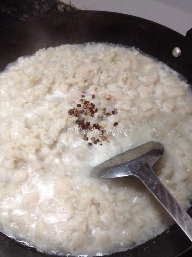 加入少许姜片、花椒粒、几粒干黄豆开盖同煮，用锅铲搅动避免粘锅底。