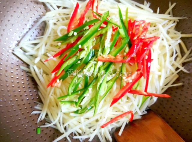 将土豆丝、青红椒一起倒入锅中